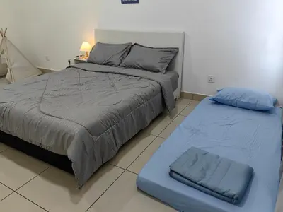 a bedroom with a bed and a blue ottoman at Warmth Nest4U Homestay Butterworth in Butterworth