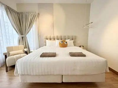 a bedroom with a large white bed with a stuffed animal on it at Tropicana 218 Macalister #softcreamy #InfinityPool #7pax #3BR2bath #Quality well maintained #Private host in George Town