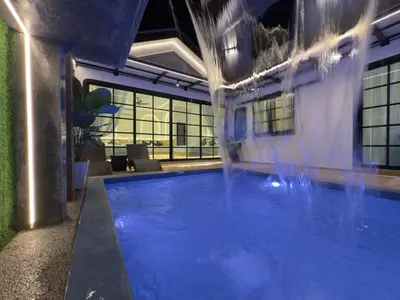 a swimming pool with a fountain in a building at LYL Ipoh Garden Private Pool Villa-18pax 5BR in Ipoh
