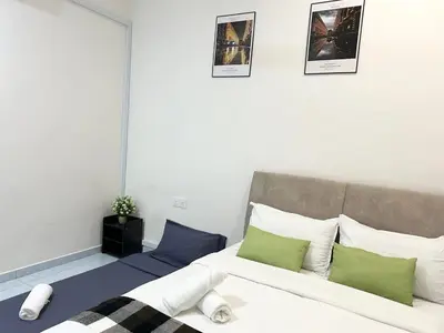 a bedroom with a bed with green and white pillows at S Home Ipoh in Ipoh