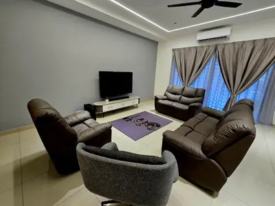 a living room with leather furniture and a flat screen tv at The Cozy 88 ipoh in Ipoh