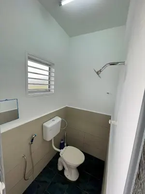 a bathroom with a white toilet and a window at Rumah Teduh in Gua Sai