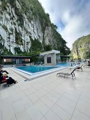 a swimming pool in front of a mountain at Small house surrounding with nature in Gua Musang