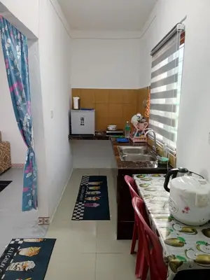 a kitchen with a sink and a counter with a table at Dhania Homestay in Gua Sai