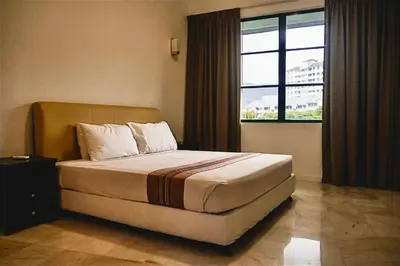 a bedroom with a bed with a large window at Stallions Suite in Jelutong