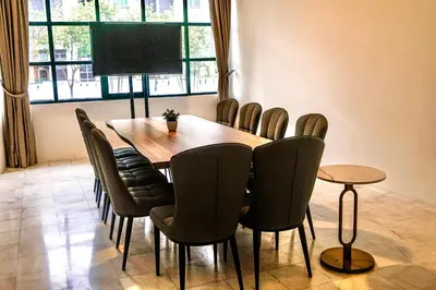 a dining room with a wooden table and chairs at Stallions Suite in Jelutong