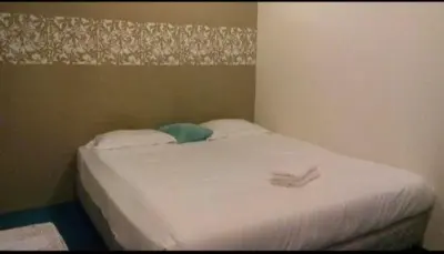 a bed in a bedroom with a white sheets and pillows at Hotel Tropicanna Pulai Point in Ipoh