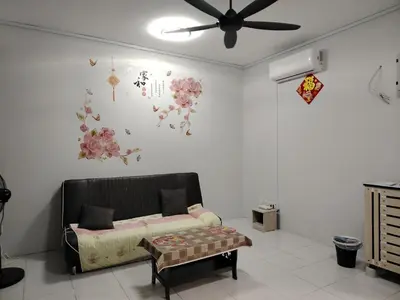 a living room with a couch and flowers on the wall at Happy Home in Kuala Kubu Baharu