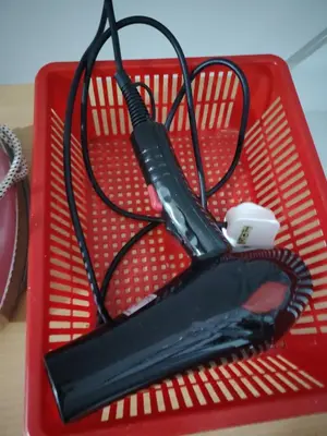 a red basket with a hair dryer on top of it at Happy Home in Kuala Kubu Baharu