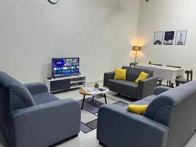a living room with blue couches and a tv at TemuHomestay in Kamunting