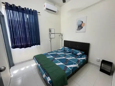 a bedroom with a bed with a blue comforter at TemuHomestay in Kamunting
