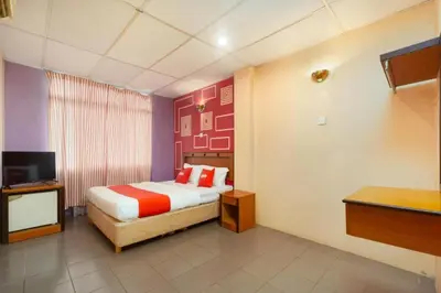 a hotel room with a bed and a television at OYO 90929 DJ Hotel in Kampung Damar Laut