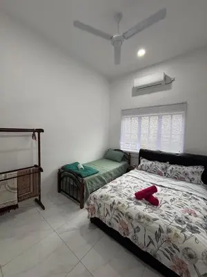 a bedroom with a bed and a window at D'Laman Homestay in Slim River