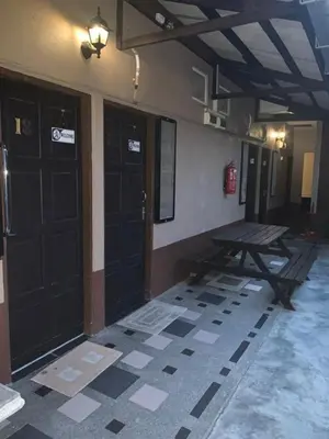 a room with two black doors and a picnic table at Nipah Bay Villa in Pangkor