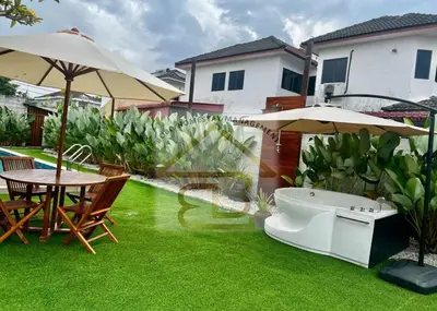 a garden with a tub and tables and umbrellas at 188 Private Pool Mansion Ipoh KTV BBQ 30Pax in Ipoh