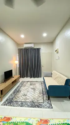 a room with a bed and a tv and a couch at Sofea Homestay Tasek Gelugor in Kampong Kubang Menderong