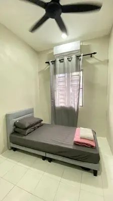 a bed in a room with a ceiling fan at Sofea Homestay Tasek Gelugor in Kampong Kubang Menderong