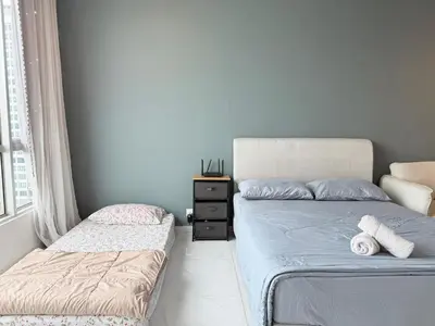 a bedroom with two beds and a dresser at Perffect JB view Paradigm UTM in Gua Sai