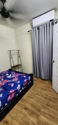 a bedroom with a bed with a blue floral bedspread at Ummi Studio Homestay in Bayan Lepas