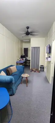a living room with a blue couch and a table at Ummi Studio Homestay in Bayan Lepas