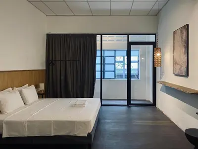 a bedroom with a bed and a large window at Chowrasta Suites by Aayu George Town Penang in George Town