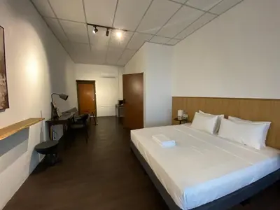 a hotel room with a bed and a desk and a room at Chowrasta Suites by Aayu George Town Penang in George Town