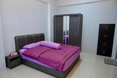 a bedroom with a bed with a purple blanket at CK Home in Ipoh