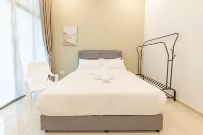 a bedroom with a large white bed with a chair at 7 \u53f7 Kota Cozy Homestay 3 storey 22pax-7 Room-SingK in Gua Sai