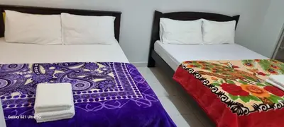two beds sitting next to each other in a room at Zahaar KN Inn in Batu Ferringhi