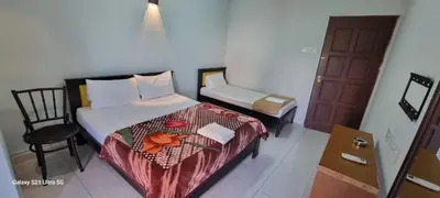 a small bedroom with a bed and a chair at Zahaar KN Inn in Batu Ferringhi