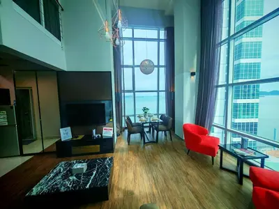 a living room with a red chair and a table at Maritime Suite by Ocean Luxe 2BR Seaview Dryer Water Dispenser in George Town