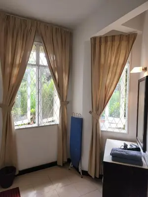 a room with two windows and a blue chair at Homestay Batu Ferringhi in Gua Sai