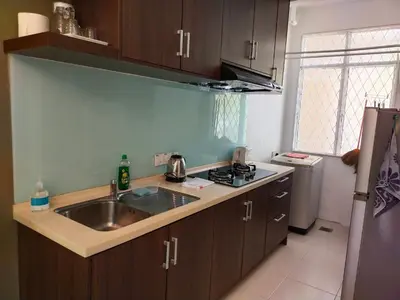 a kitchen with a sink and a refrigerator at Homestay Batu Ferringhi in Gua Sai