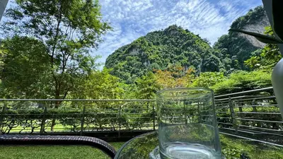 a glass vase sitting on a table with a view of mountains at The Haven Lakeside Residences, Lake View Suite IPOH in Gua Sai