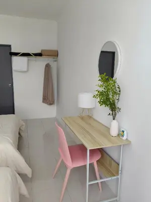 a desk and a pink chair in a room at Almira Homestay in Brinchang