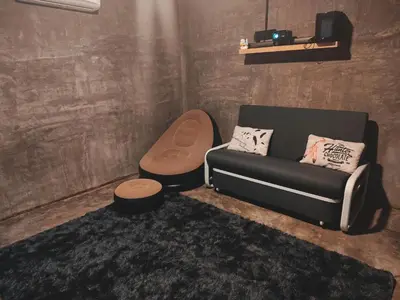 a living room with a couch and a stool at Afqa Nest Industrial Charm in Gua Sai