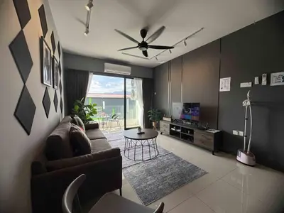 a living room with a couch and a tv and a table at Manhattan Ipoh Family Suites By Inn Lux in Ipoh