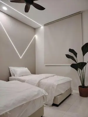 a bedroom with two beds and a ceiling fan at Relax Guest House Bakap Indah in Kampong Gurun