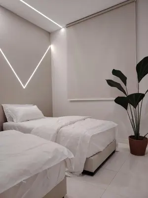 a bedroom with two beds and a potted plant at Relax Guest House Bakap Indah in Kampong Gurun