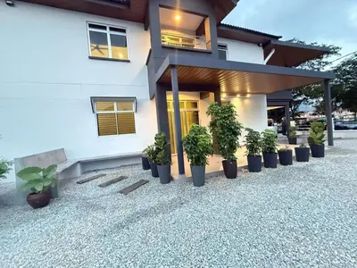 a house with potted plants in front of it at Relax Guest House Bakap Indah in Kampong Gurun