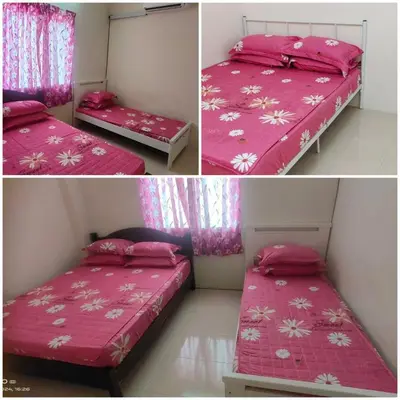a bedroom with two beds with pink covers at Luna Homestay Lumut in Lumut