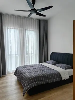 a bedroom with a bed and a ceiling fan at The Glen Apartment Kuching in Gua Sai