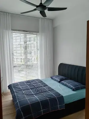 a bedroom with a bed with a ceiling fan at The Glen Apartment Kuching in Gua Sai