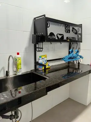a kitchen counter with a sink and a tv on a wall at The Glen Apartment Kuching in Gua Sai