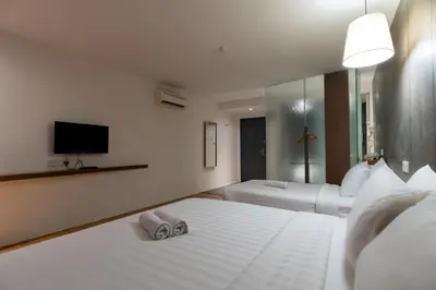 a bedroom with two beds and a flat screen tv at T+ Hotel Butterworth in Butterworth