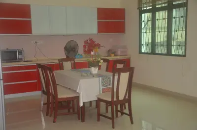 a kitchen with a table with chairs and a table and a kitchen at Kulim LakeView Homestay at Golf Resort in Kulim