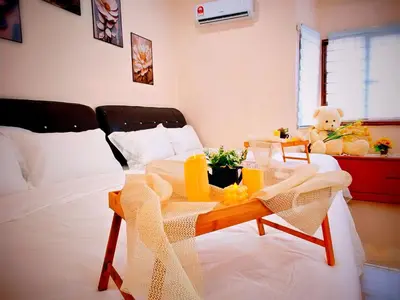a bed with a table with a teddy bear on it at Ipoh Happy Home Boutique Villa by City Home Empire in Ipoh