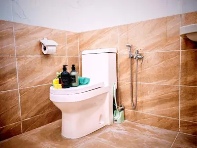 a bathroom with a toilet with bottles on the tank at Ipoh Happy Home Boutique Villa by City Home Empire in Ipoh