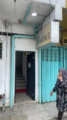 a woman walking in front of a building at \u5343\u5c9b\u7f8e\u4eba\u9c7c\u9152\u5e97 in Gua Sai