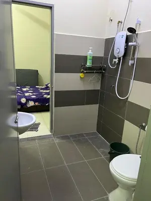 a bathroom with a shower and a toilet and a bed at RB Homestay Modern Comfort in Hutan Melintang